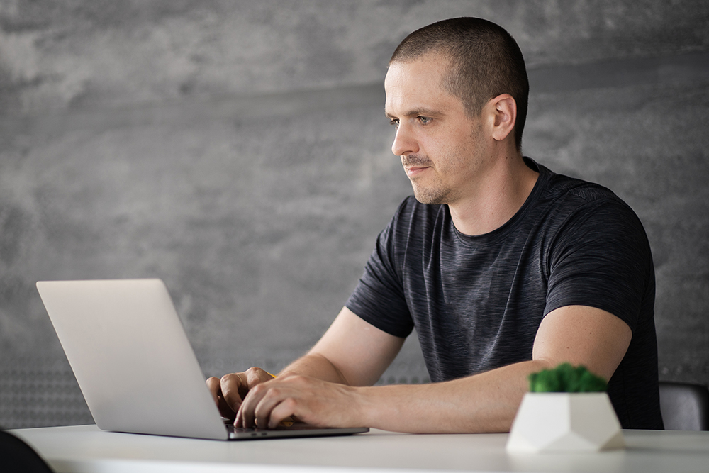 Man show how is he strong with laptop in hand