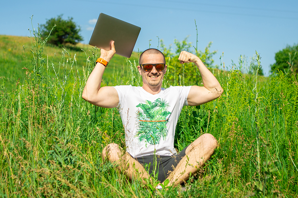 Man show how is he strong with laptop in hand